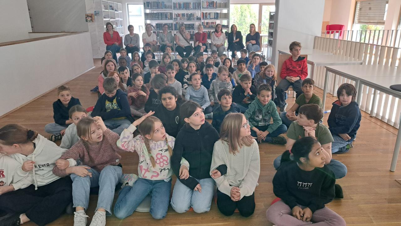 vor der Preisverleihung, alle Kinder warten gespannt auf das Ergebnis, im Hintergrund die Lehrerinnen, die Direktorin, die Jury-Mitglieder