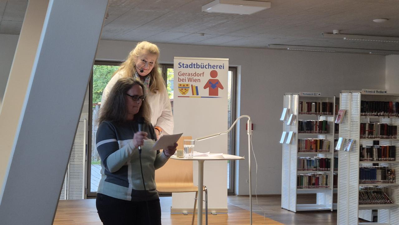2 Frauen auf der Bühne, eine hält ein Mikrofon in der Hand