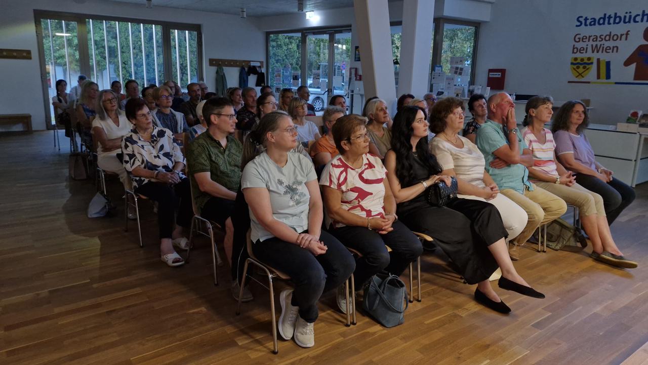 das Publikum von vorne, zahlreiche sitzende Menschen