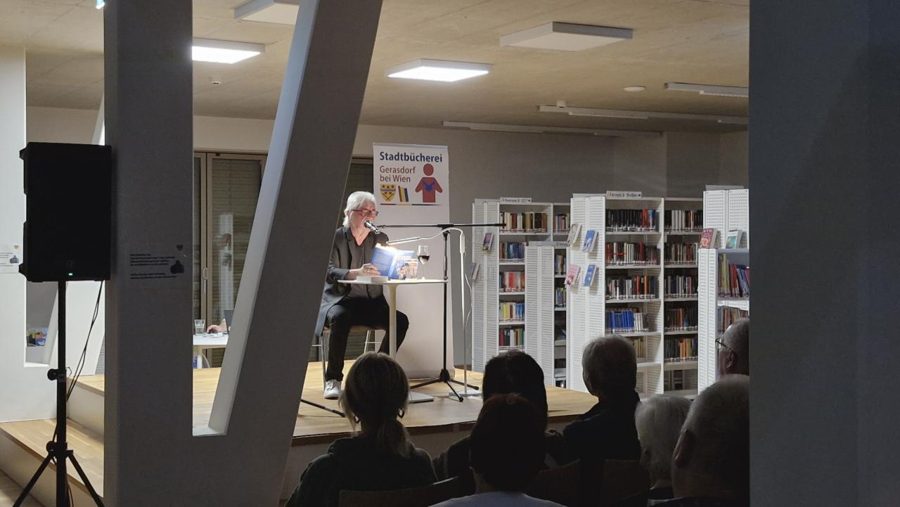 der Künstler auf der Bühne, davor ein Teil vom Publikum
